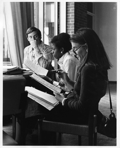 Black and white photograph of three Fletcher School students studying in the library.