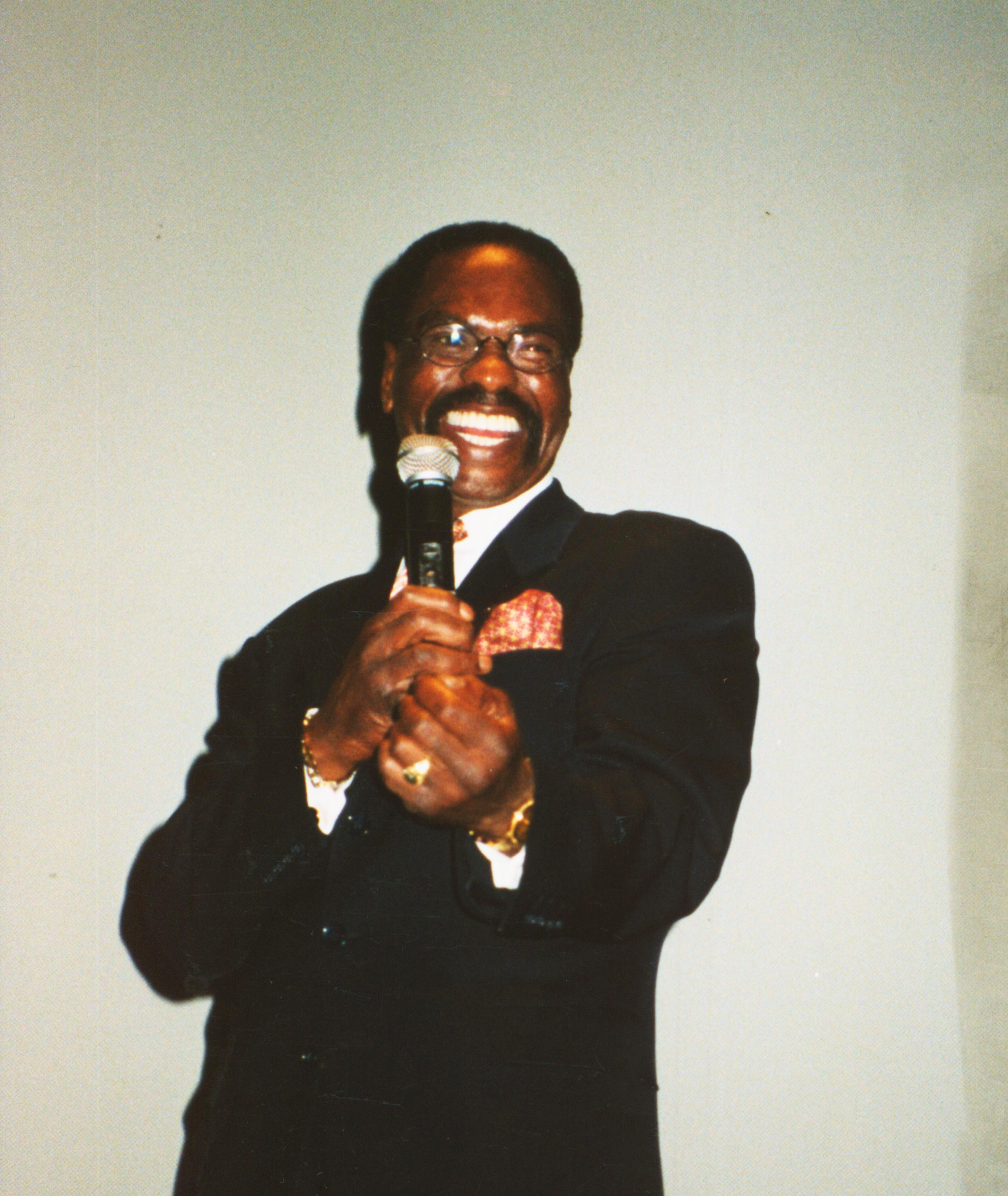 Rubin Carter smiling holding a microphone