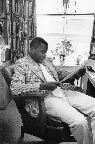 Black and white photo of Professor Bernard Harleston reviewing papers, circa 1975