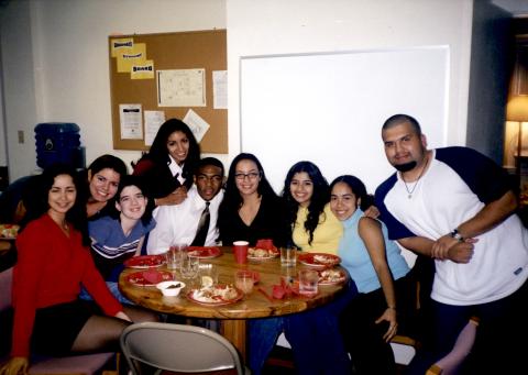 Students in the Latinx Center gathered around a table with cups and plates on it.